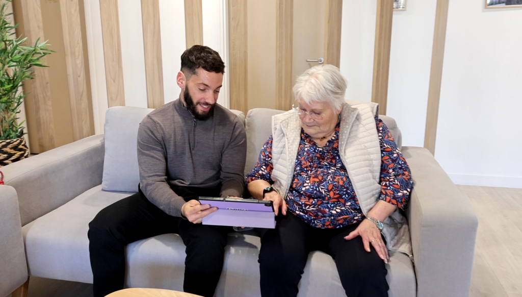 1 animateur de résidence senior joue avec 1 résidente sur une tablette à Gena-App